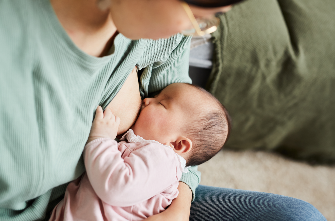 A new mother breastfeeding her newborn baby. View from the top. Concept of breast engorgement, breastfeeding, swollen breasts, postpartum.