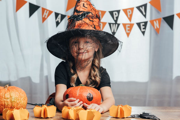 A young child dressed for Halloween. Eco-friendly decorations in the background.